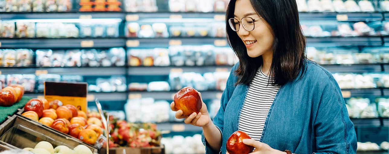 Woman picking apples in grocery store